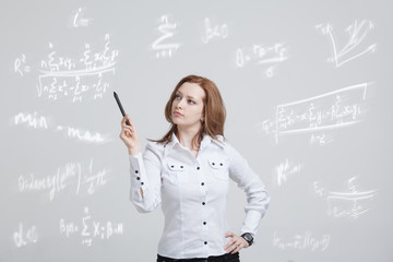 Woman scientist or student with pen working with various high school maths and science formula.