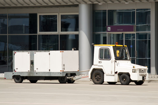 Tractor With Airport Ground Power Unit At Arrival Gate