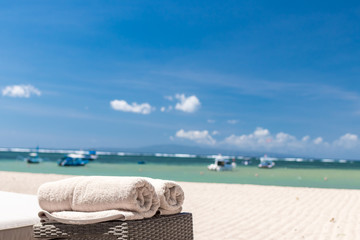 Cream beach towel on the ocean background. Tropical Bali island, Indonesia.