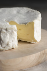 Camembert cheese on a wooden board. Close-up, Rustic French still life