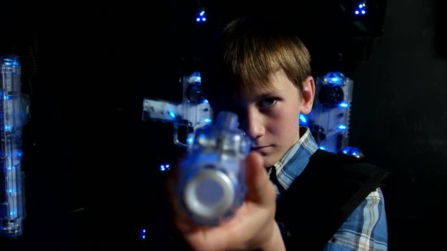 Child with a laser tag weapon takes aim at the camera