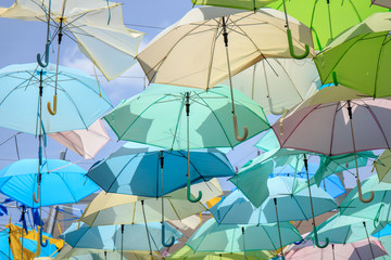 Colorful umbrella hang as ceiling with blue sky.