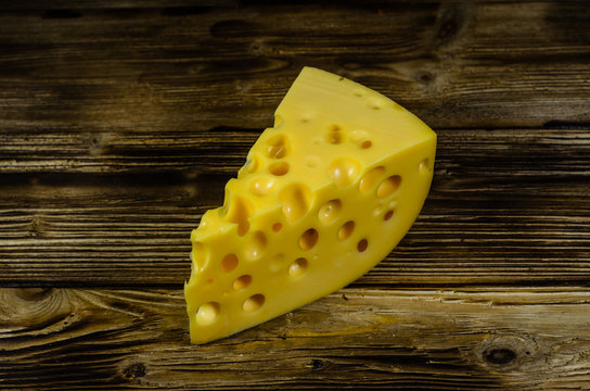 Piece of cheese on wooden table