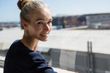 Smiling woman standing by window in office