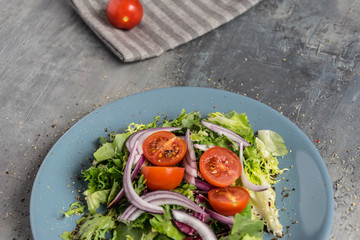 Light salad with three kinds of salads, fresh tomatoes, olive oil and balsamic and roasted pastries