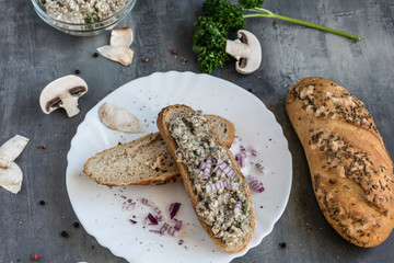 Fresh pastry with champignon spread on a gray background with whole colored pepper and pieces of mushrooms