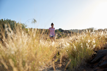 Girl walking through very long grass