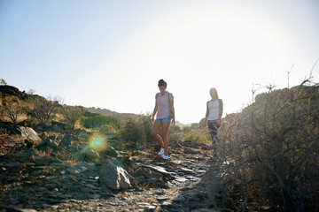 Two girls walking a rocky pathway