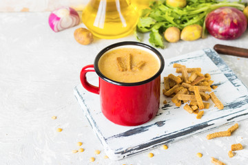 Pea soup with mashed potatoes in red enamel mug