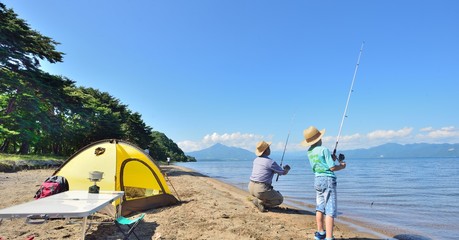 湖畔のキャンプ・釣りを楽しむファミリー