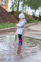 Little girl staying in the puddle