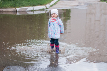 Child jumping in the puddle