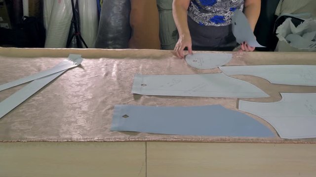 A tailor choosing pattern placement on cloth.  