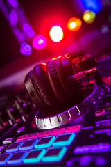 Dj mixer with headphones at a nightclub - obrazy, fototapety, plakaty