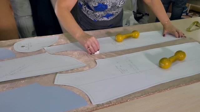 A tailor transfers paper patterns on fabric. 