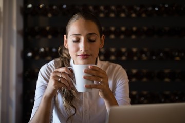 Smiling woman having coffee in cafe