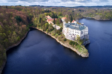 Aerial view on czech romantic, gothic chateâu Orlik, situated on rock outcrop above  Orlik reservoir in beautiful spring nature. Romantic,royal Schwarzenberg castle above water level. Czech landscape. - obrazy, fototapety, plakaty