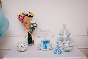 торт, букеты и кэнди-бар на фоне стены и воздушных шариков