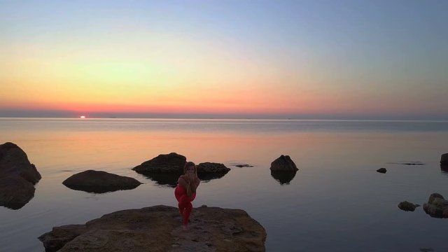 Young woman do Yoga garudasana eagle pose sea reef dawn drone footage aerial