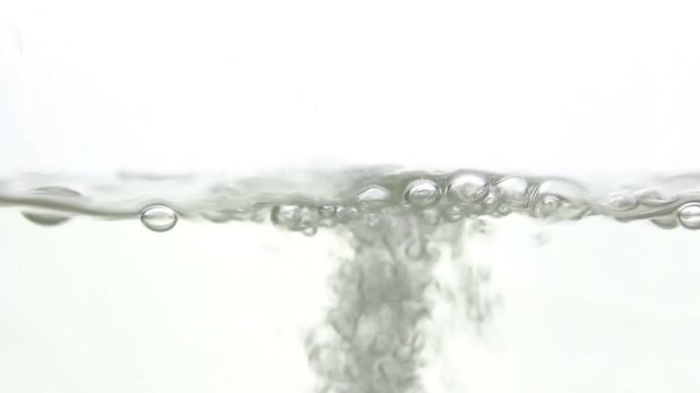A rush of water in a glass close up