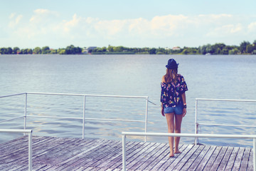 Woman sitting on a pontoon on the edge of a lake