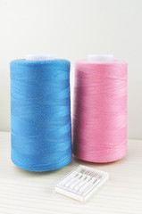 spools of blue and pink thread