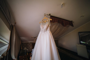 Wedding dress on hanger on a wall. 