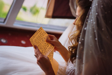 Young beautiful bride is reading a letter from a groom