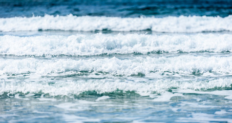 Big surfing ocean sea waves on sandy beach.