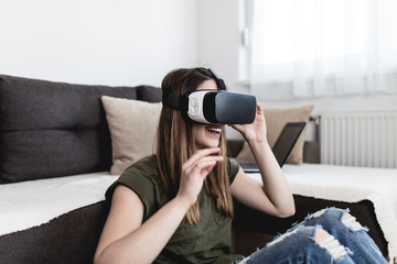 Beautiful young woman enjoying virtual reality at her home.