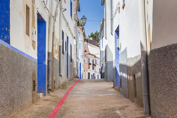 Fototapeta na wymiar Red line running through a narrow street in Ayora