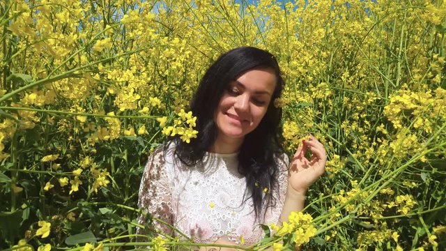 Beautiful girl is relaxing among yellow flowers