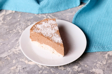 Three chocolate mousse cake with cocos slice on a small plate