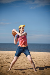 Happy girl on the beach playing ball