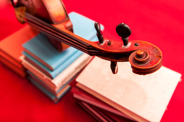 Fototapeta na wymiar Music instrument old violin on a book and pile of books