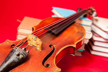 Fototapeta premium Music instrument old violin on a book and pile of books