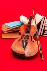 Music instrument old violin on a book and pile of books