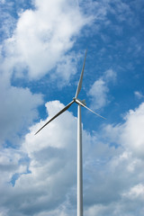 Wind turbine with cloud background on the sky.