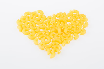 Dried pasta or elbow macaroni over white background - love shape