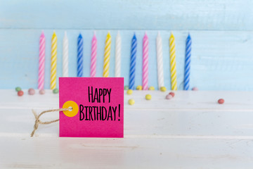 birthday candles and happy birthday message card isolated on a wooden background