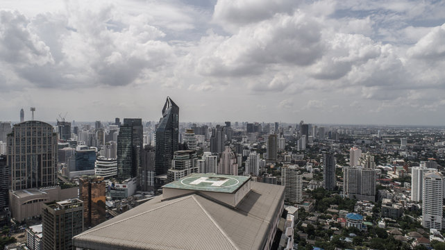 Aerial drone view of helipad isolated on top of the skycraper in Bangkok city during cloudy day