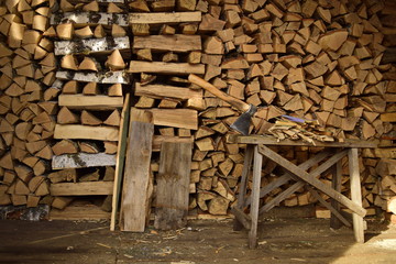 the axe in the woodshed. The axe on the background of firewood
