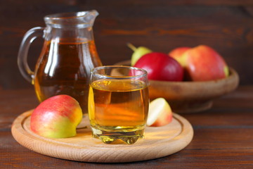 Apple juice and fruit on a dark wooden background.