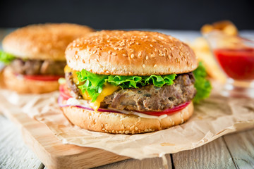 Classic tasty hamburger with tasty beef and tomato sauce on dark background