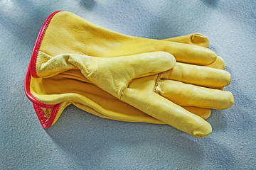 Pair of leather safety gloves on concrete background building co