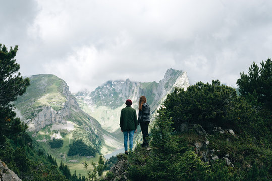 Couple looking over a valley with lake in the Switzerland Mountains
