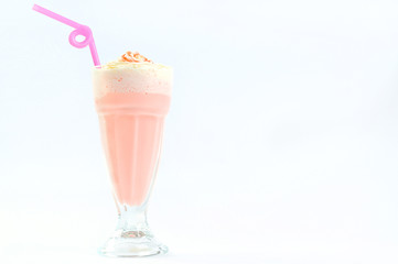 Pink milkshake in high glass with a straw.