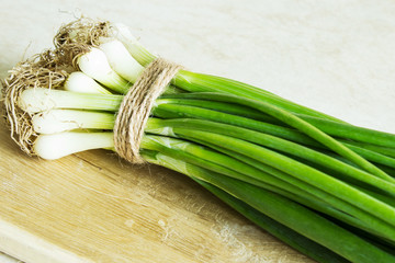A bunch of fresh raw green onions on a wooden background. Country style. Selective focus. ©  Iryna	