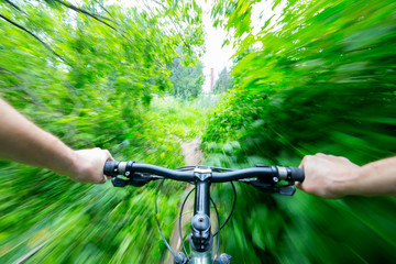 Fototapeta na wymiar Mountain biking down hill descending fast on bicycle.