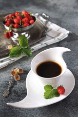 Wild strawberry and cup of black coffee